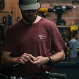 The Woods Cyclery Embroidered Logo T-Shirt - Stonewashed Burgundy